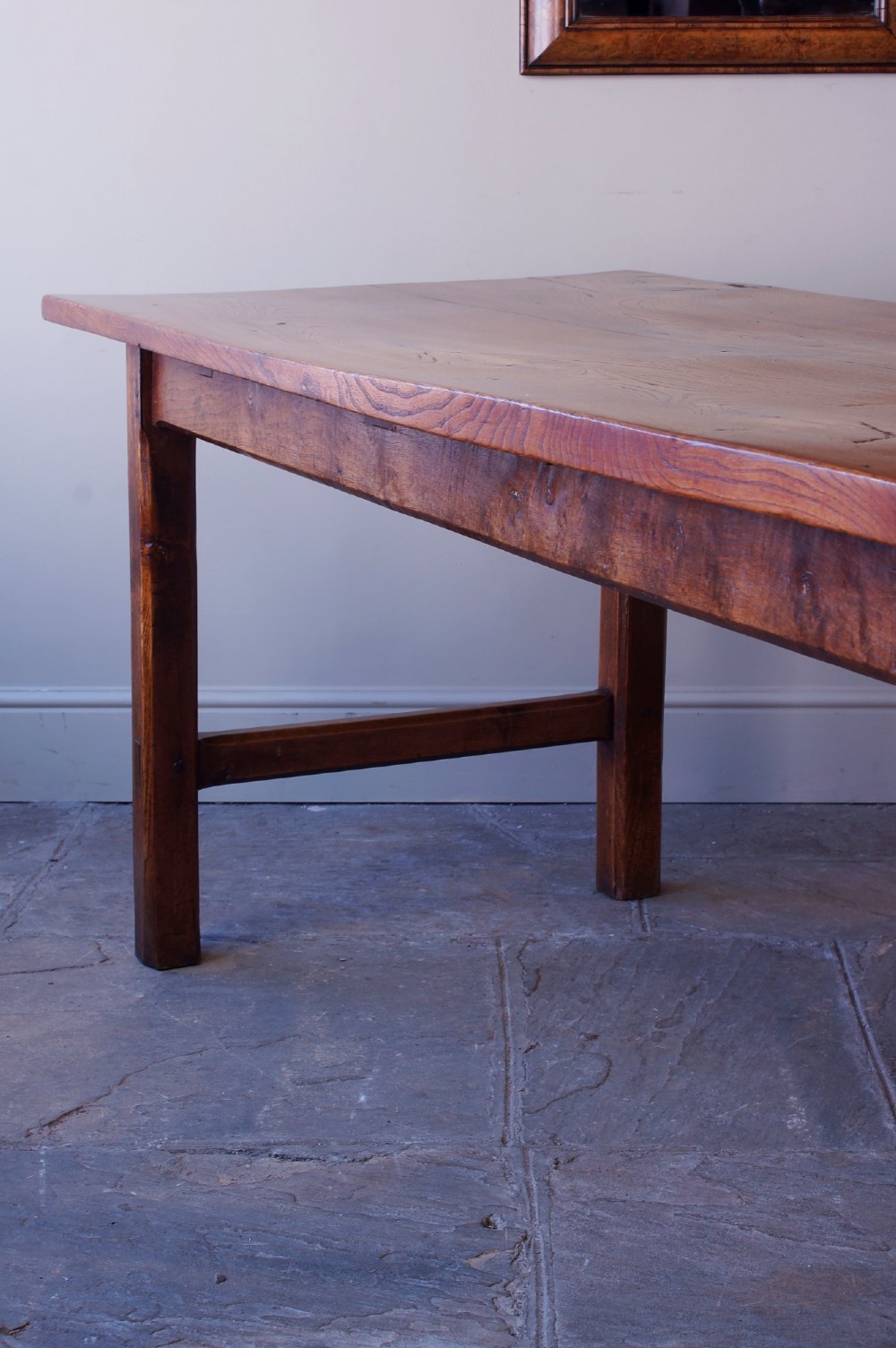 A long nineteenth-century elm farmhouse dining table with a thick plank top, straight legs, and side stretchers. View VIII