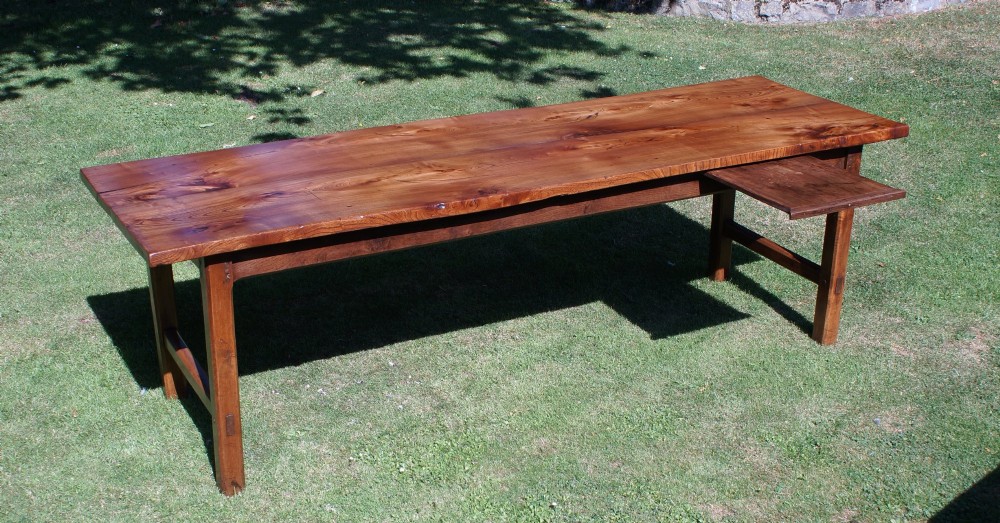 A long nineteenth-century elm farmhouse dining table with a thick plank top, straight legs, and side stretchers. View IX