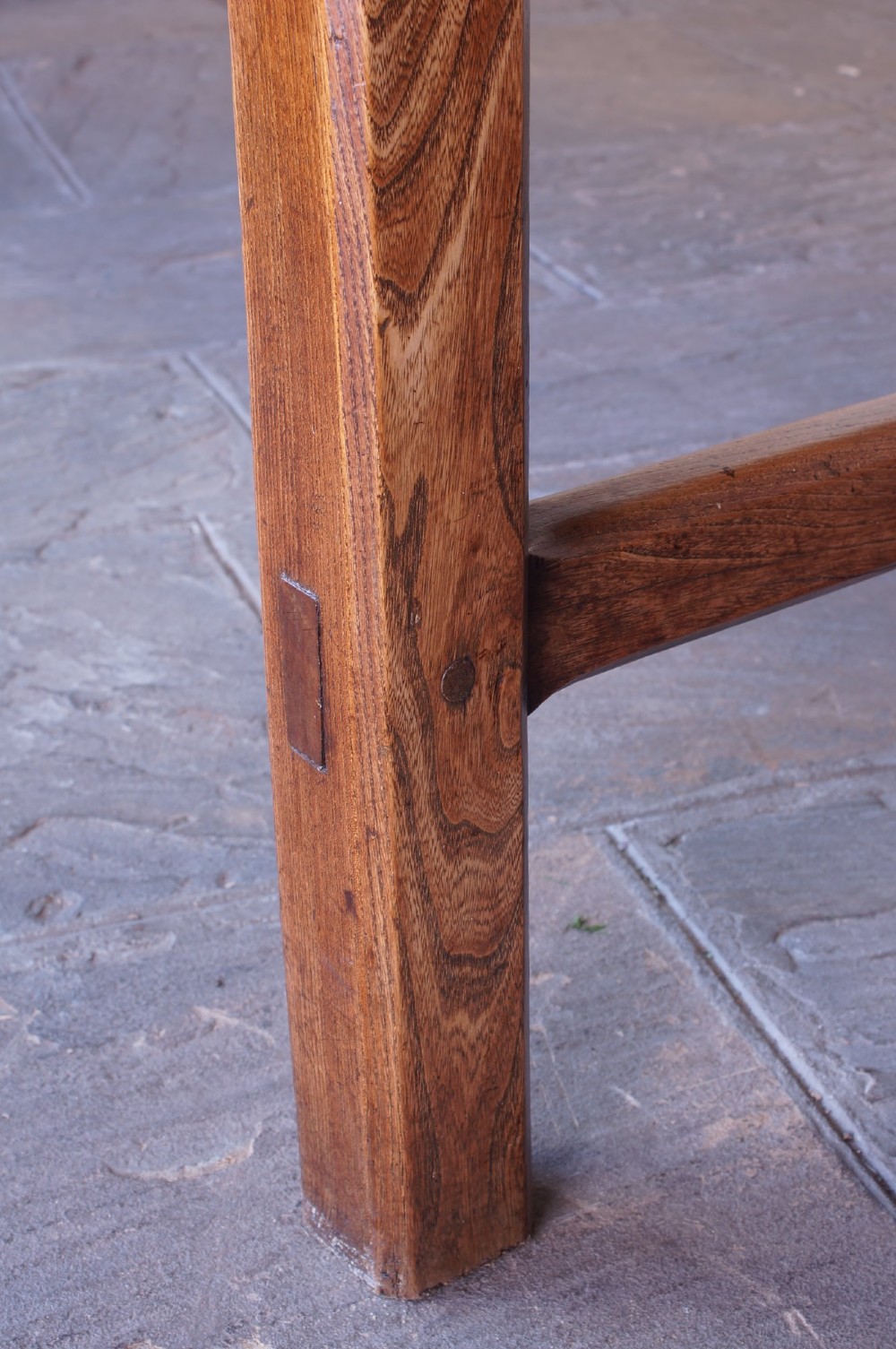 A long nineteenth-century elm farmhouse dining table with a thick plank top, straight legs, and side stretchers. View X