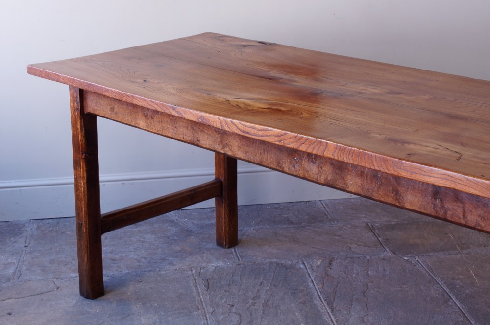 A long nineteenth-century elm farmhouse dining table with a thick plank top, straight legs, and side stretchers. View XII