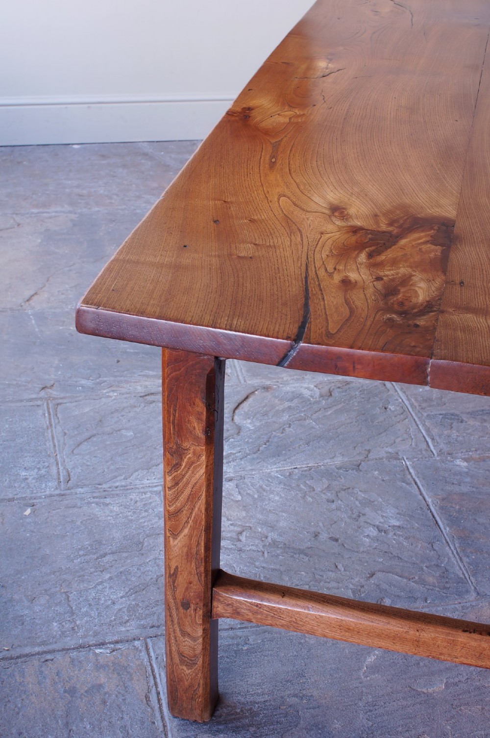 A long nineteenth-century elm farmhouse dining table with a thick plank top, straight legs, and side stretchers. View XIII