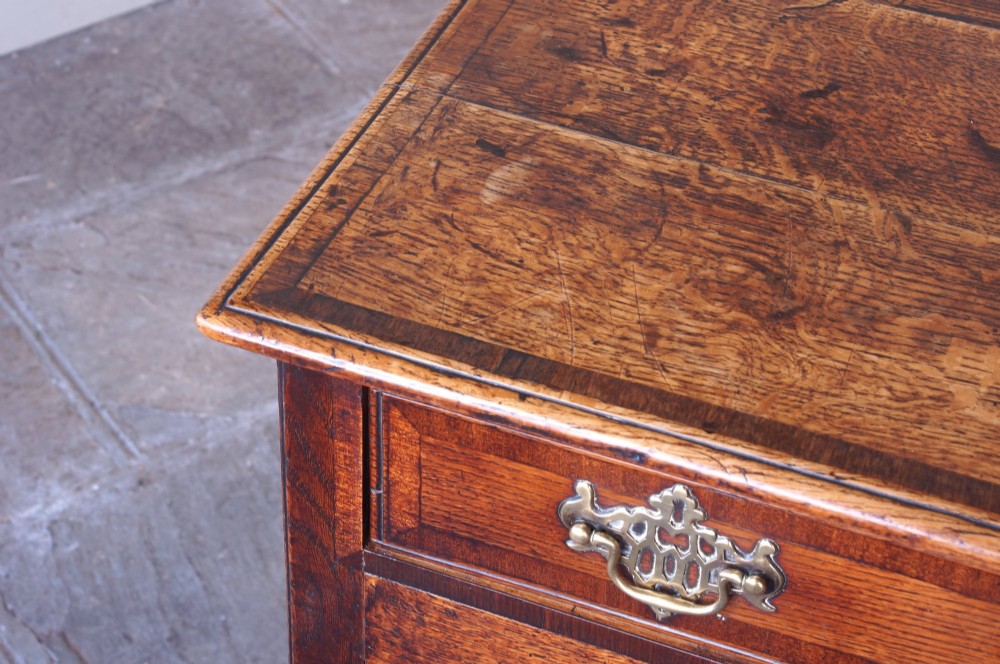 An 18th-century Georgian oak side table featuring a single drawer with decorative brass backplates and handles, set above a shaped apron and straight legs. View III