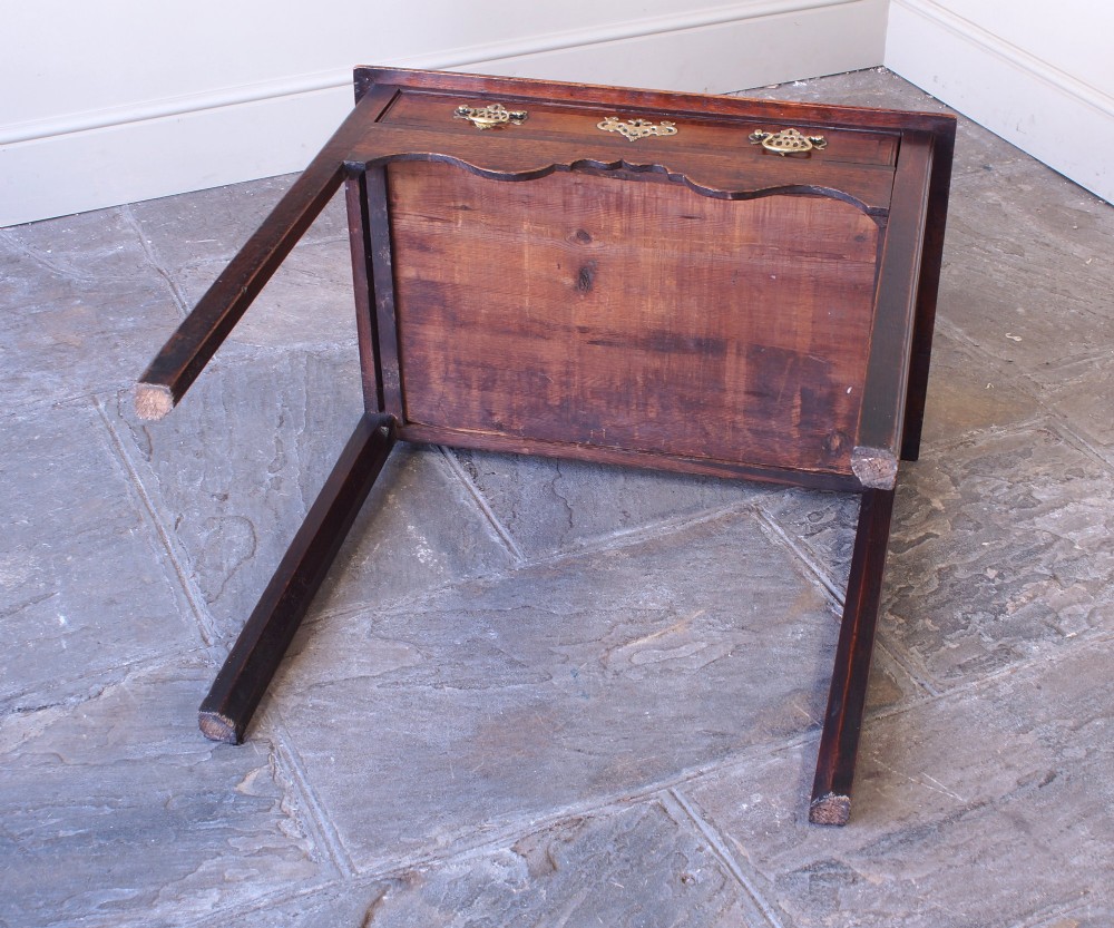 An 18th-century Georgian oak side table featuring a single drawer with decorative brass backplates and handles, set above a shaped apron and straight legs. View XII