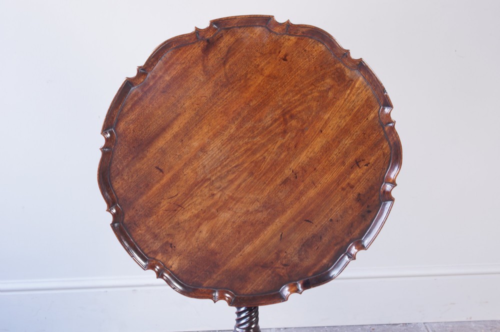 An 18th-century George III mahogany tripod table with a scalloped piecrust tilt-top, turned spiral column standard, and carved cabriole legs. View III