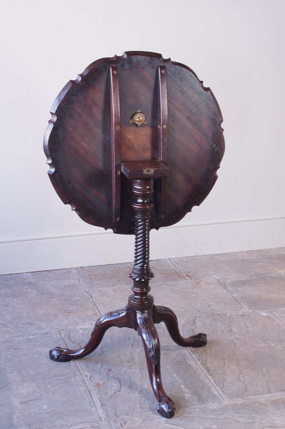 An 18th-century George III mahogany tripod table with a scalloped piecrust tilt-top, turned spiral column standard, and carved cabriole legs. View V
