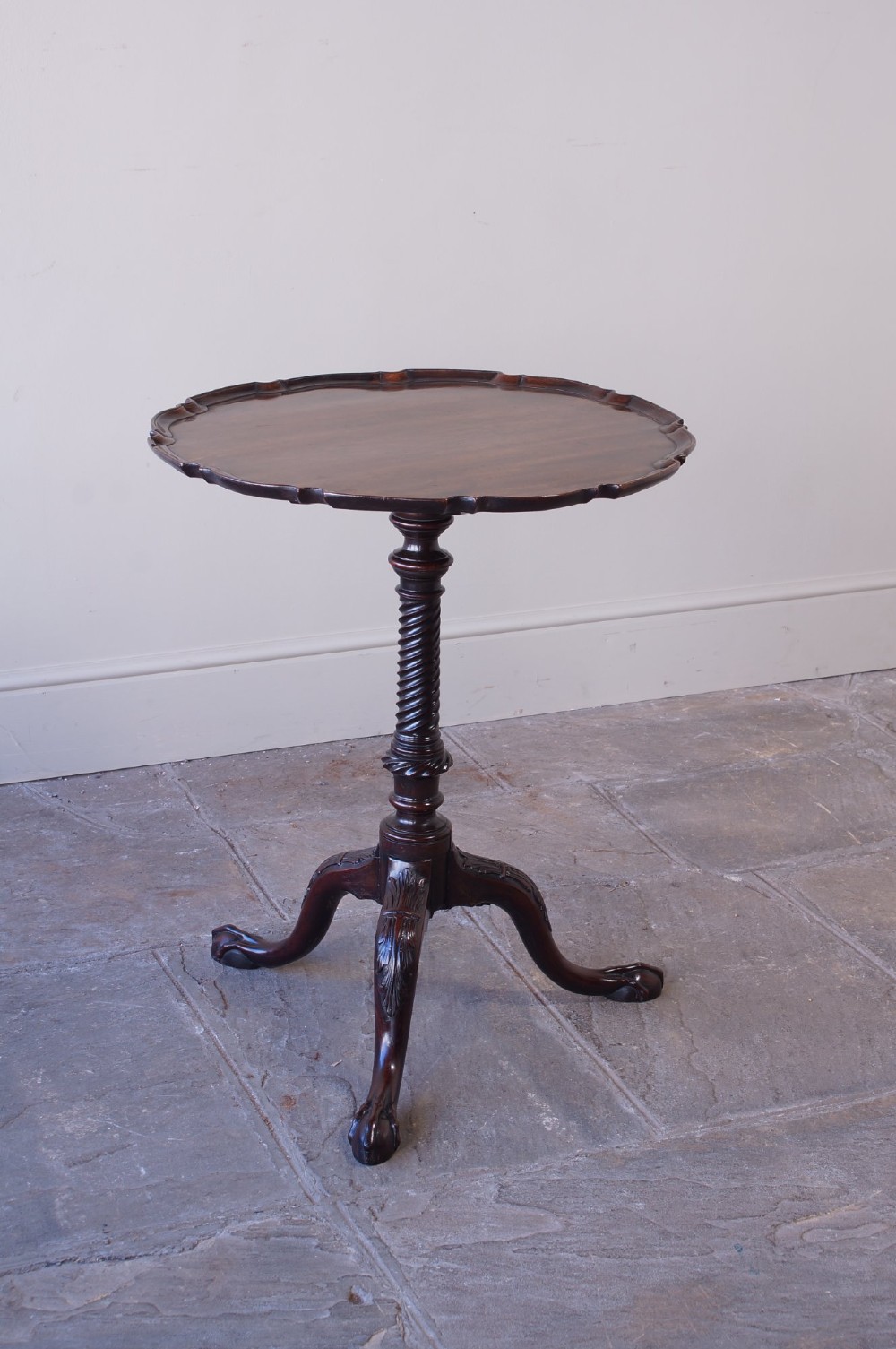 An 18th-century George III mahogany tripod table with a scalloped piecrust tilt-top, turned spiral column standard, and carved cabriole legs. View XI