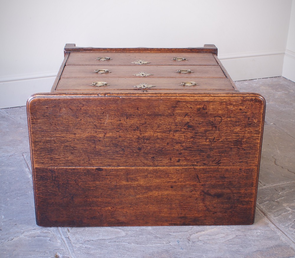 An early eighteenth-century oak chest of drawers featuring two short over three long drawers with brass drop handles and bracket feet. View XII