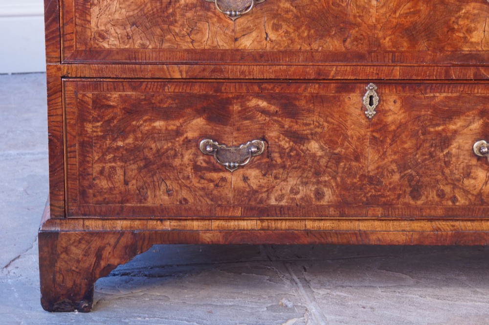 An 18th-century chest on chest crafted from figured ash featuring multiple graduated drawers with brass drop handles and bracket feet. View II