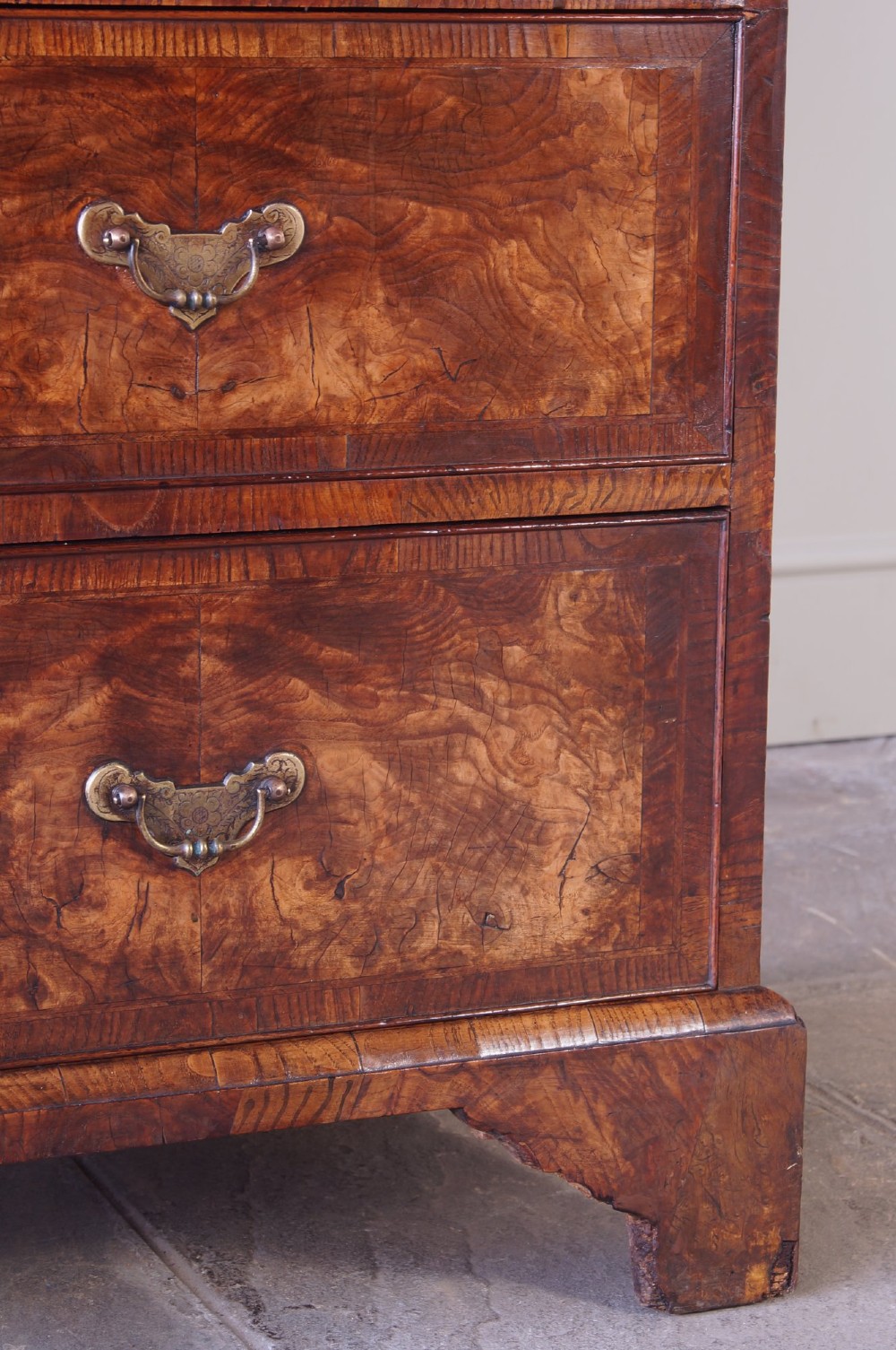 An 18th-century chest on chest crafted from figured ash featuring multiple graduated drawers with brass drop handles and bracket feet. View III