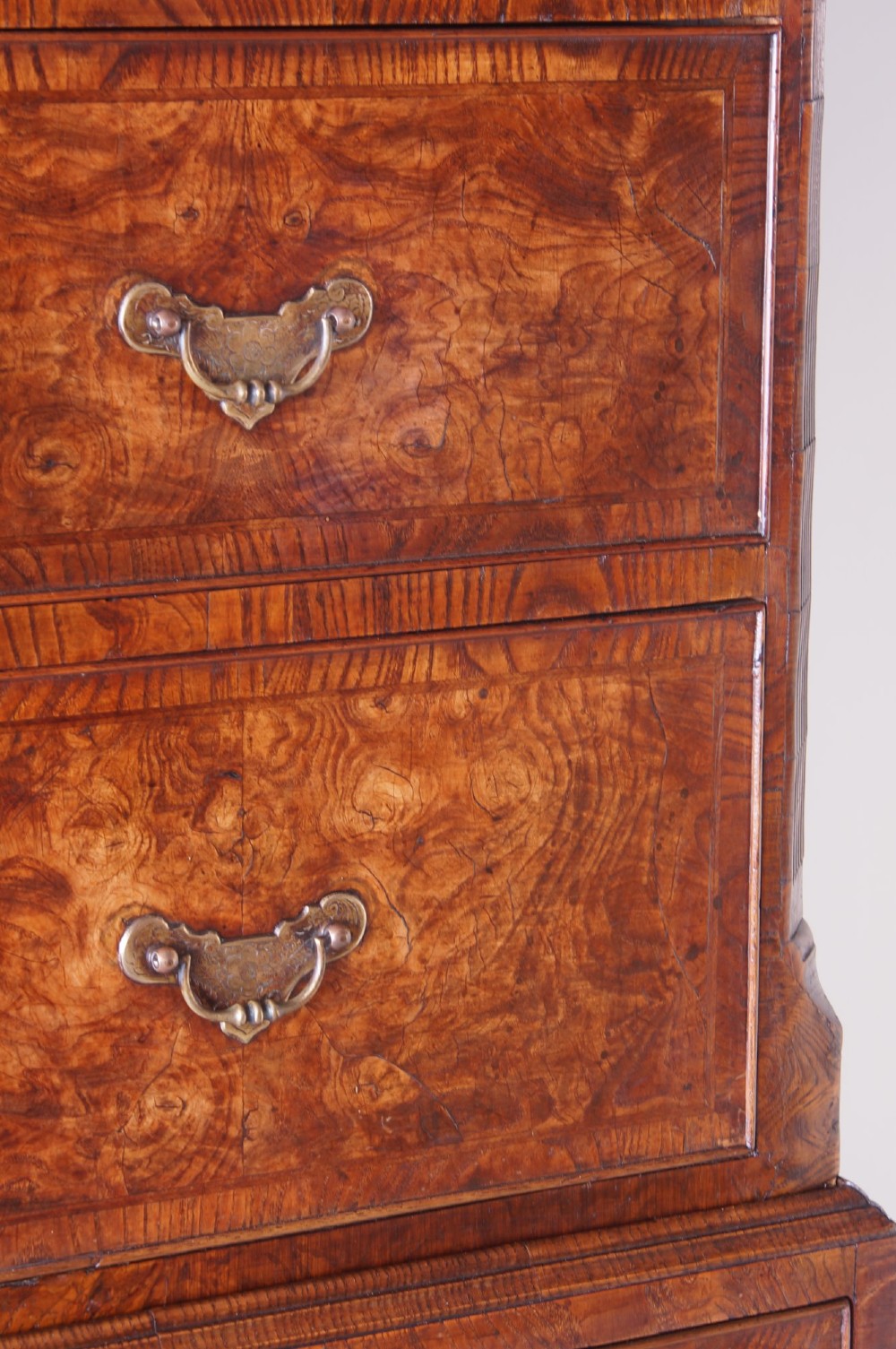 An 18th-century chest on chest crafted from figured ash featuring multiple graduated drawers with brass drop handles and bracket feet. View IV