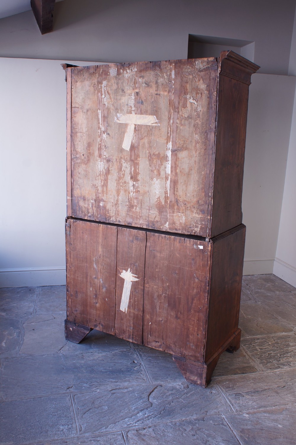 An 18th-century chest on chest crafted from figured ash featuring multiple graduated drawers with brass drop handles and bracket feet. View VI