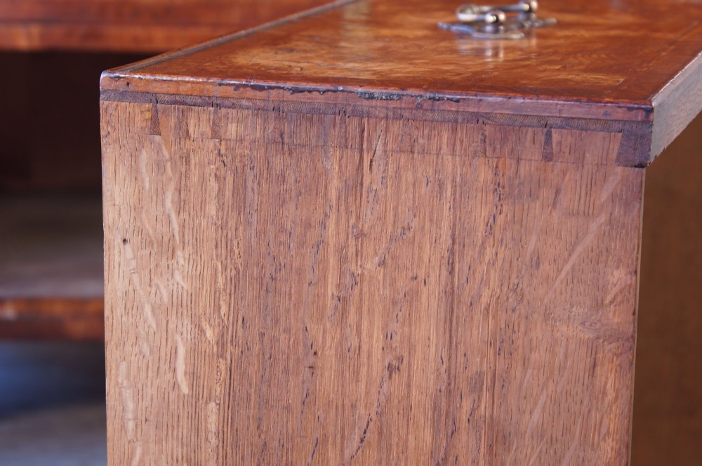 An 18th-century chest on chest crafted from figured ash featuring multiple graduated drawers with brass drop handles and bracket feet. View XIII