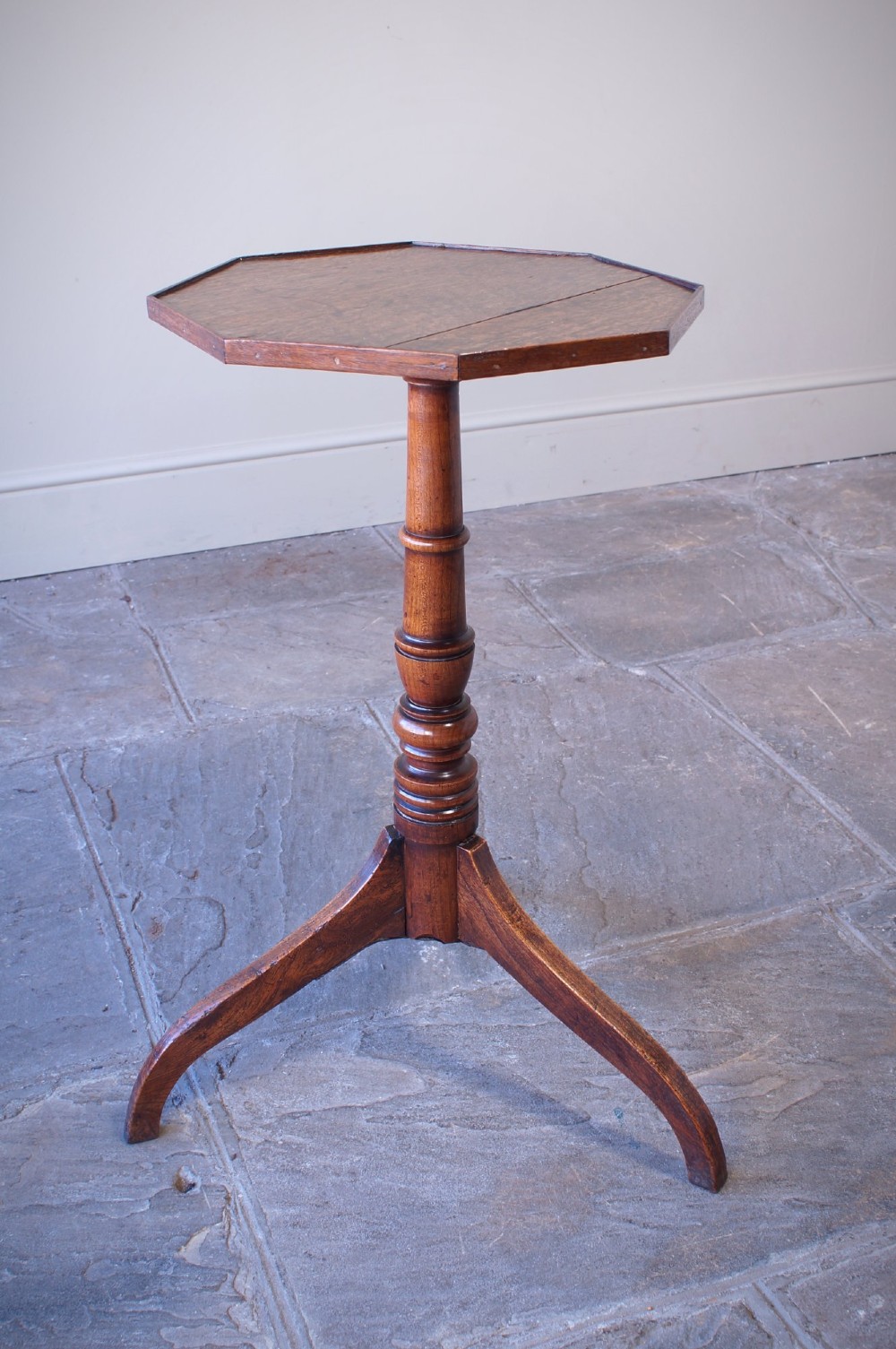 A Georgian oak and elm wine table featuring an octagonal top over a turned pedestal base with three down-swept tripod legs. View II