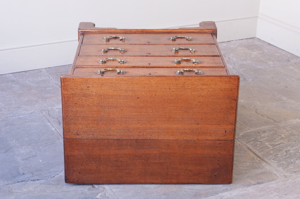 A small Georgian oak chest of drawers featuring four graduated drawers with brass swan-neck handles and bracket feet. View IX
