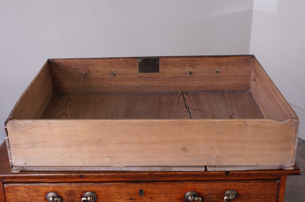 A small Georgian oak chest of drawers featuring four graduated drawers with brass swan-neck handles and bracket feet. View XI