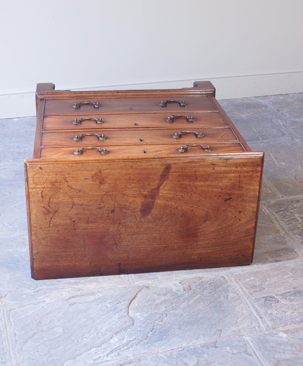 An 18th-century Georgian mahogany chest of drawers featuring four graduated drawers, brass swan-neck handles, keyhole escutcheons, and bracket feet. View IV