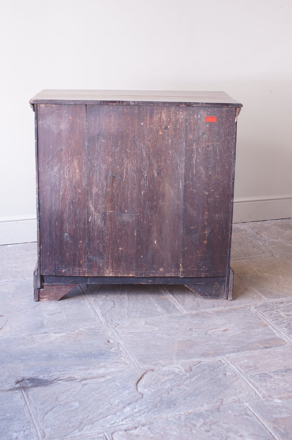 An eighteenth-century fruitwood chest of drawers with two short over three long graduated drawers, brass swan-neck handles, keyhole escutcheons, and shaped bracket feet. View VII