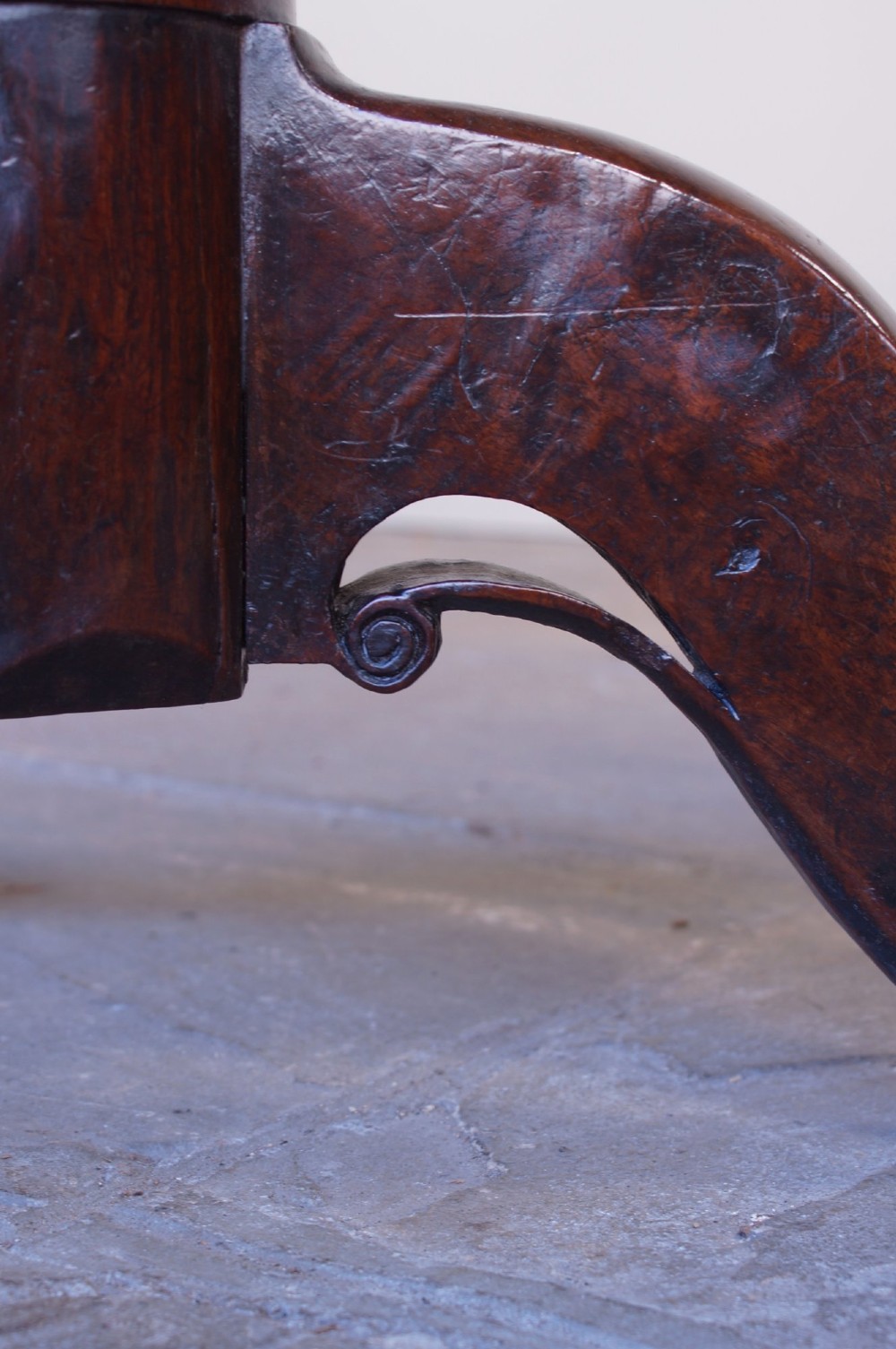 A Georgian oak tilt-top table with a circular planked top shown tilted vertically on a turned pedestal stem and tripod legs. View X