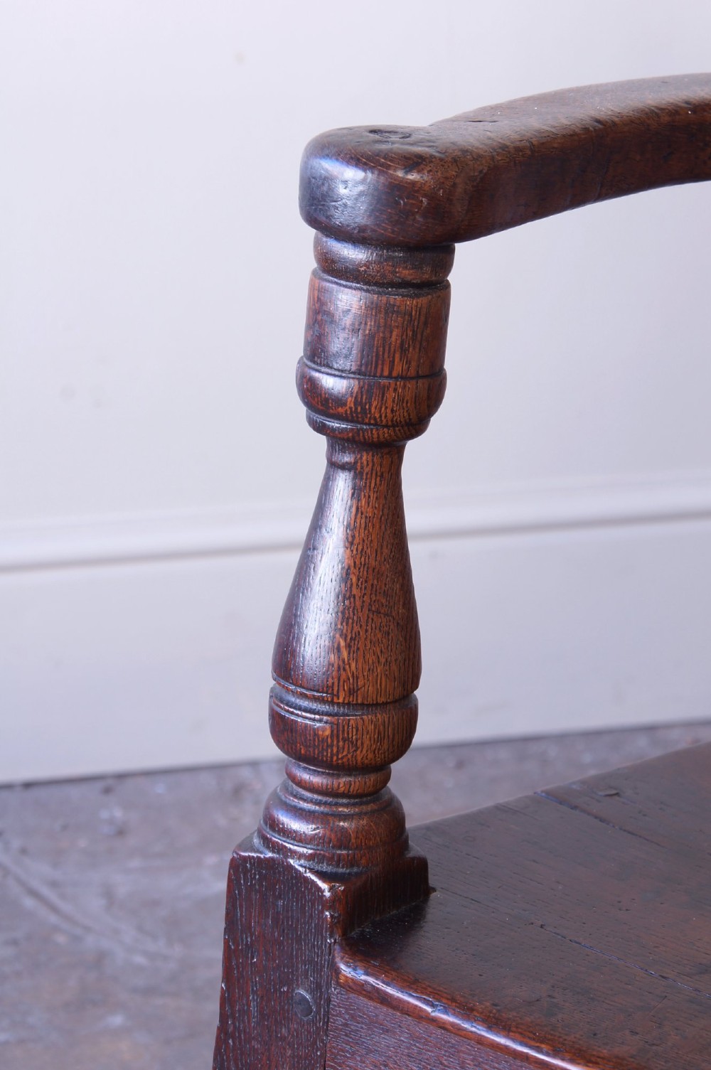 A dark brown 17th-century oak childs wainscot armchair with carved geometric back panels and turned supports. View VII