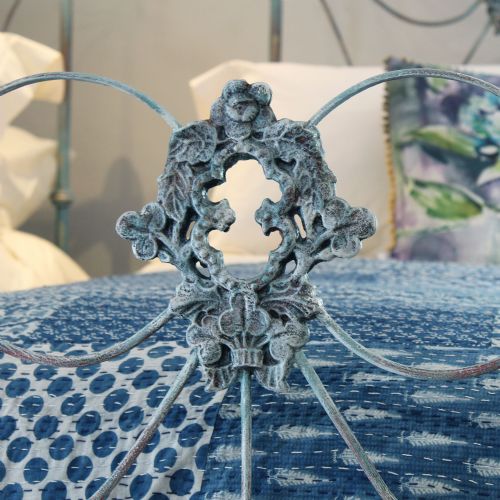 fig 2. A matching pair of single cast iron beds featuring scrollwork headboards and footboards finished in a blue verdigris patina.