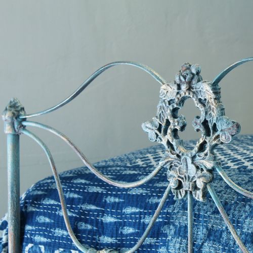 fig 3. A matching pair of single cast iron beds featuring scrollwork headboards and footboards finished in a blue verdigris patina.