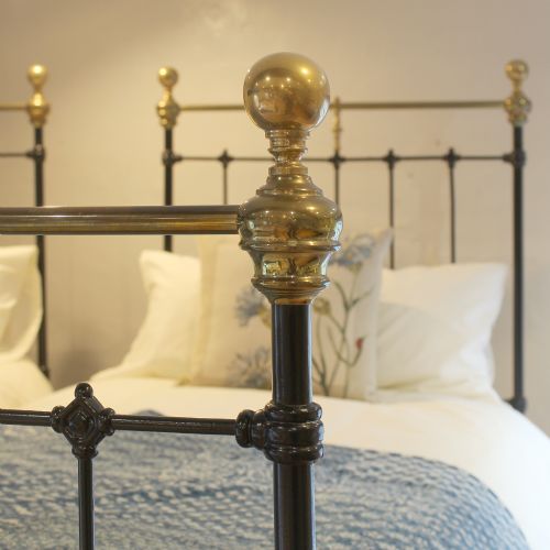 fig 2. A matching pair of Victorian black cast iron single beds featuring vertical spindles and polished brass top rails with urn finials.