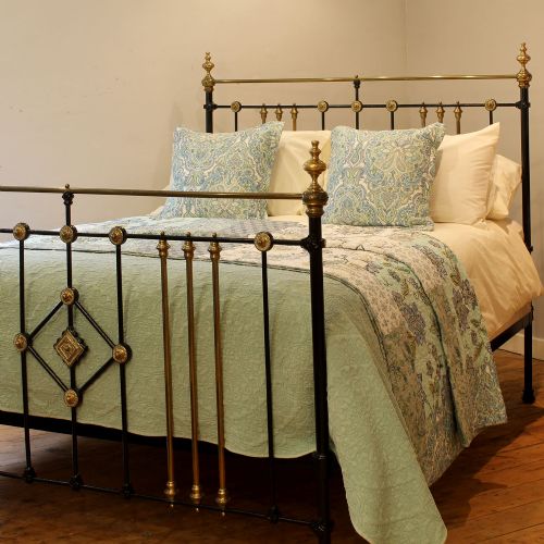 fig 1. A Victorian black painted cast iron and brass king-size bedstead featuring turned brass finials, vertical spindles, and a central brass diamond motif.