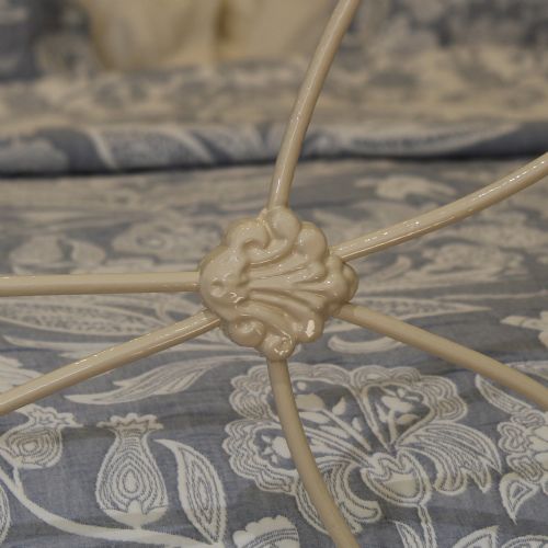 fig 1. A cream painted antique cast iron double bed frame with decorative geometric metal scrollwork and polished brass finials on the corner posts.