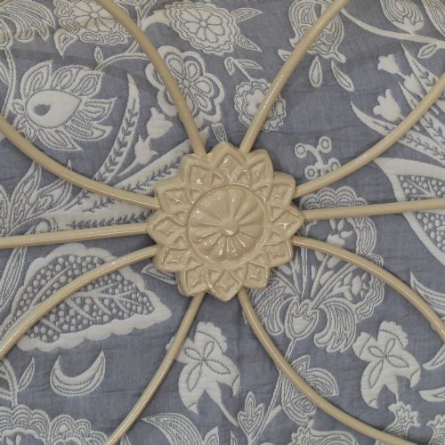 fig 2. A cream painted antique cast iron double bed frame with decorative geometric metal scrollwork and polished brass finials on the corner posts.