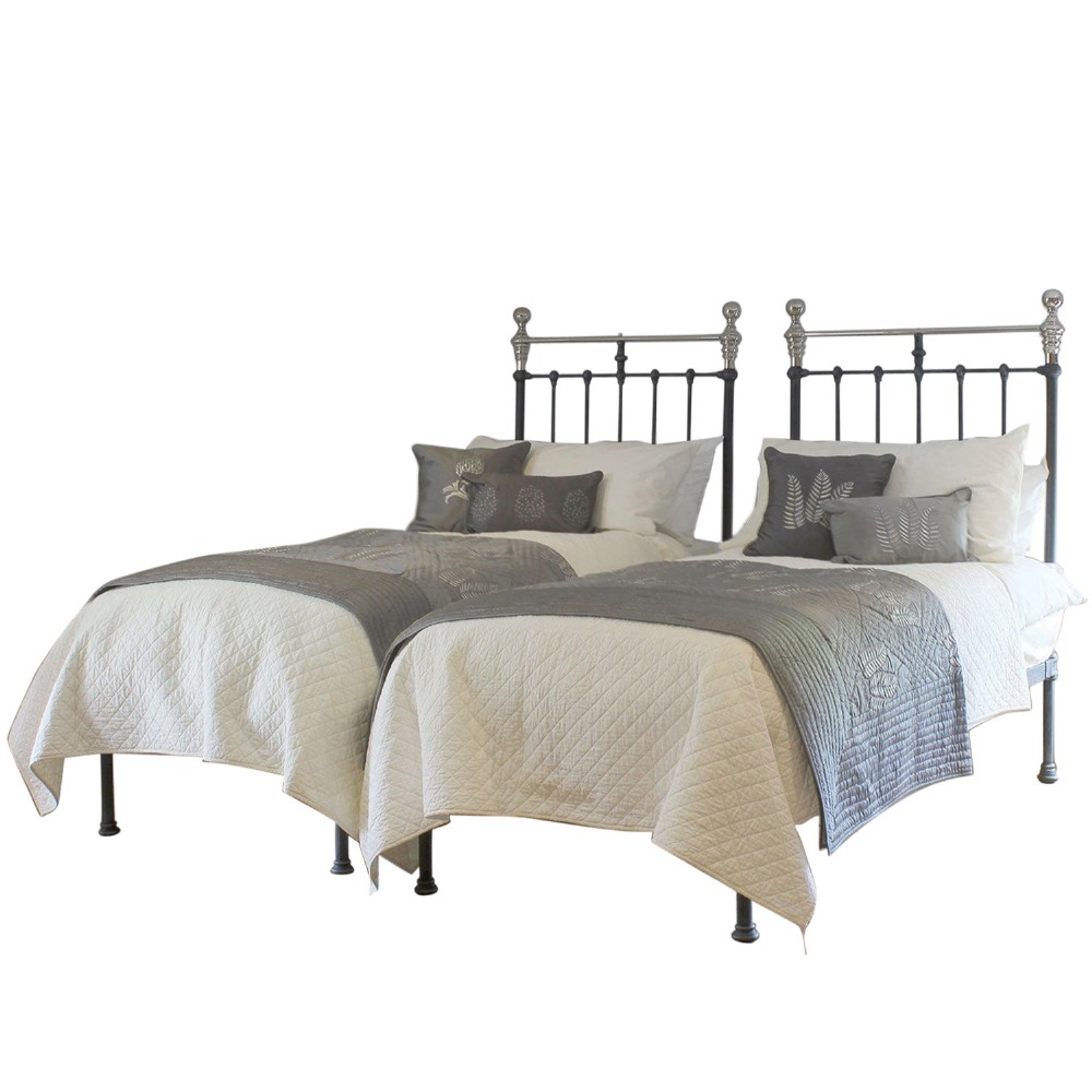 A pair of single metal platform beds featuring dark charcoal vertical spindles and polished nickel top rails with spherical finials.