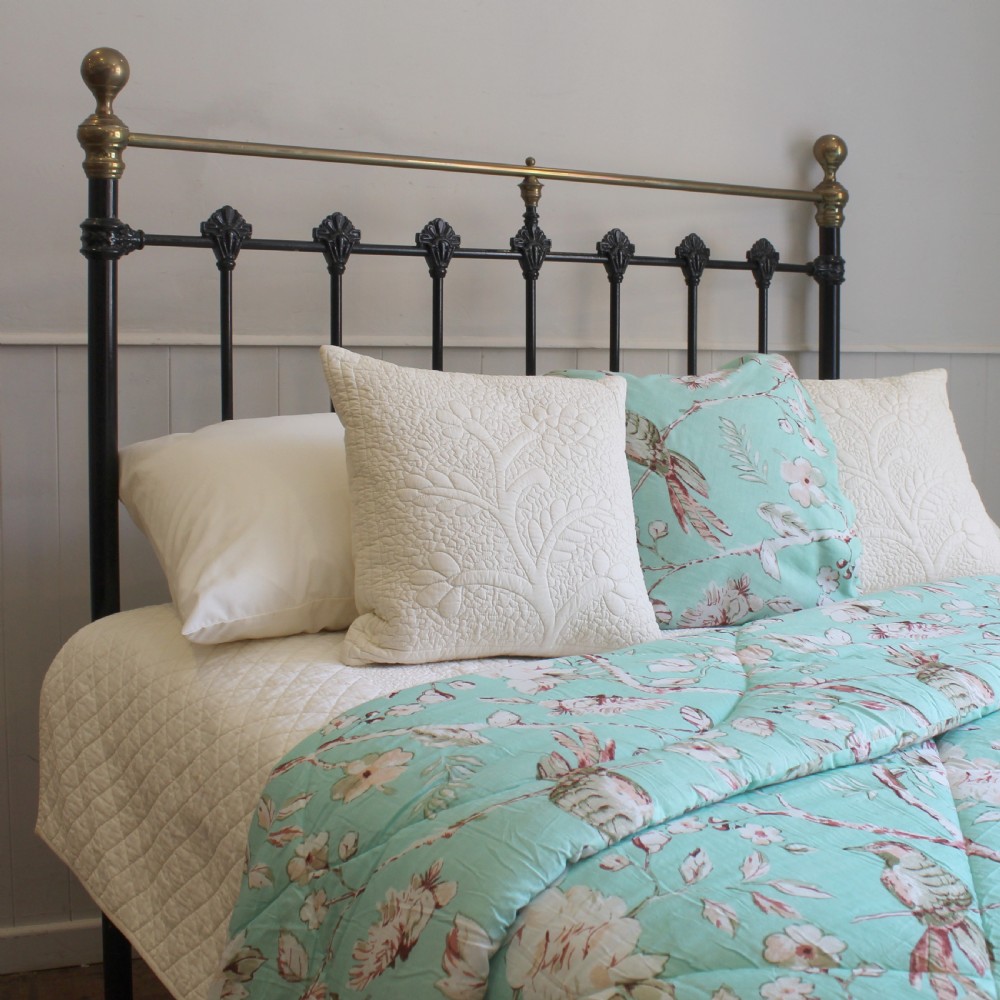 A Victorian black cast iron double bed frame featuring brass top rails, brass corner finials, and vertical iron spindles with ornate cast decorative joints. View VII