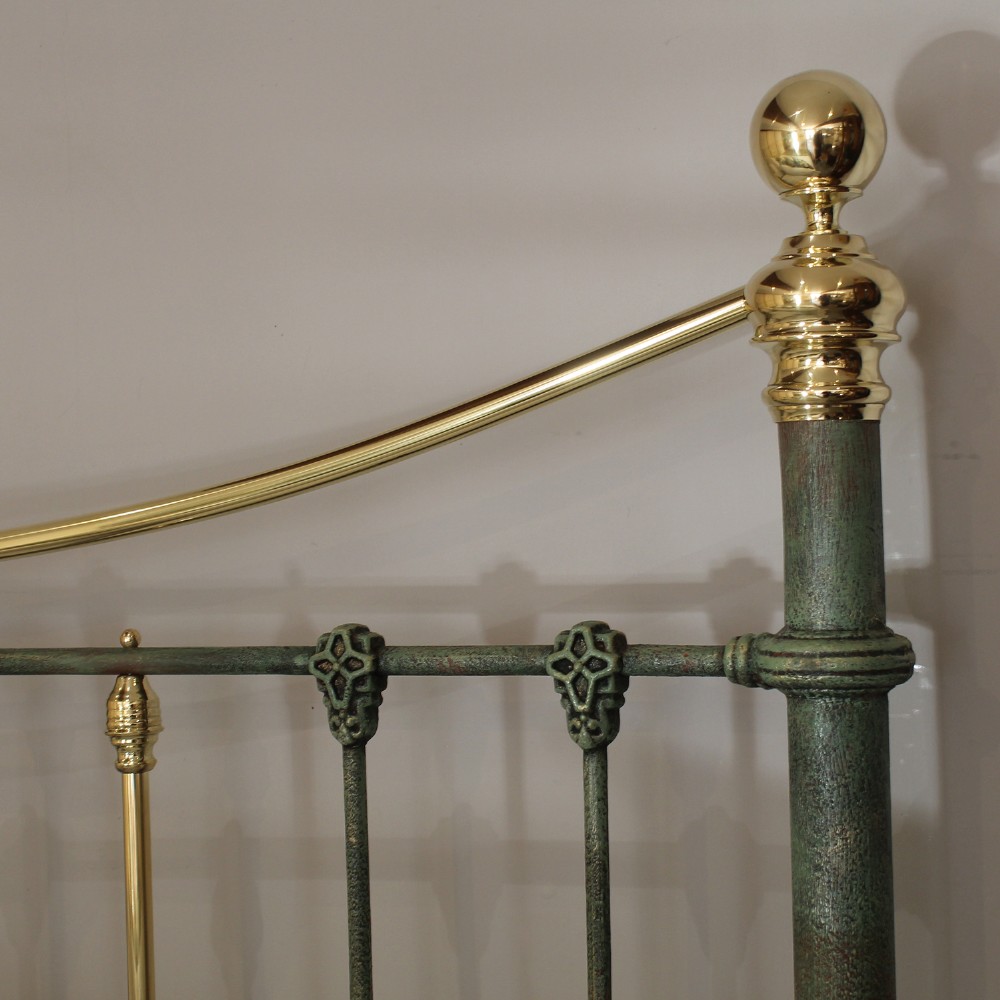 A king-size green painted metal bedstead featuring curved brass top rails, polished brass finials, and vertical central spindles. View III
