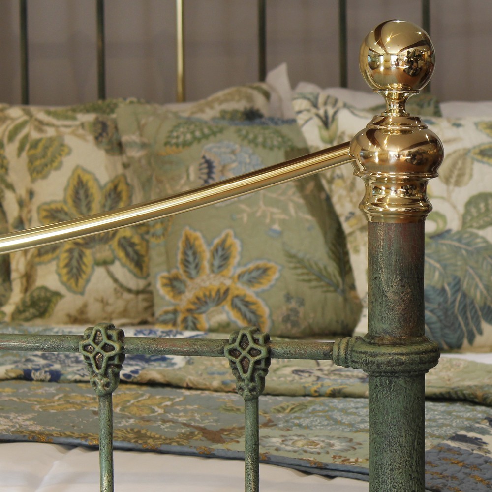 A king-size green painted metal bedstead featuring curved brass top rails, polished brass finials, and vertical central spindles. View IX