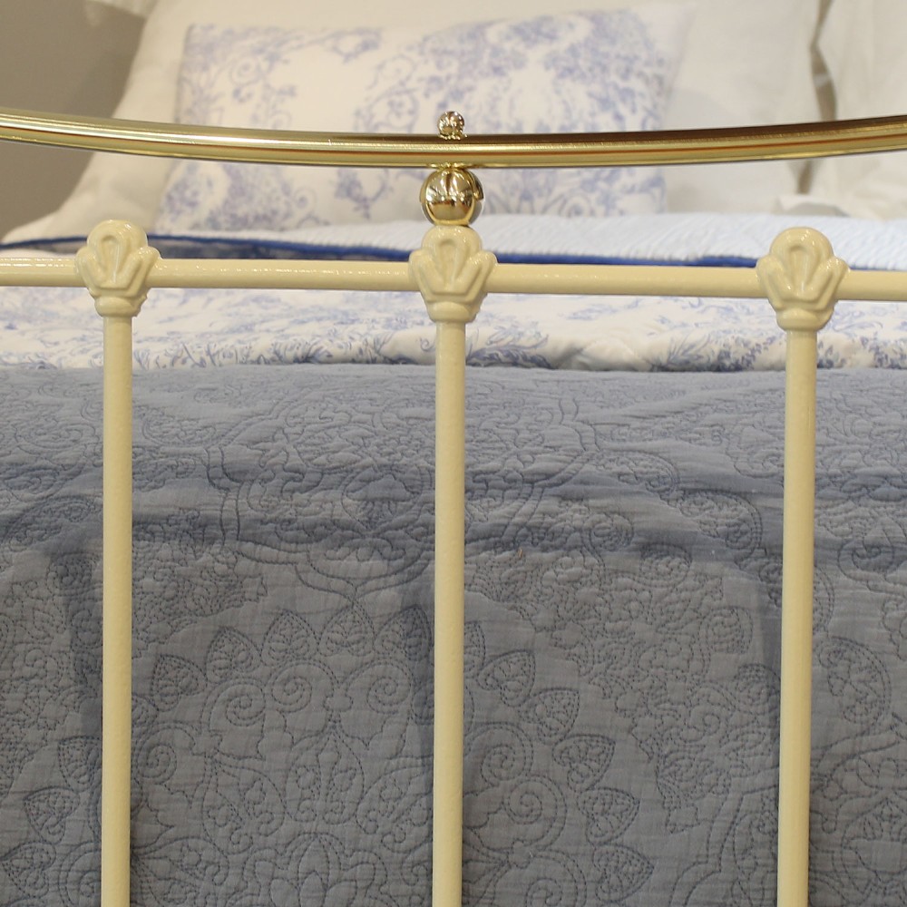 An antique king-size cream-painted metal bedstead featuring polished brass top rails, brass finials, and vertical spindle detailing. View VI