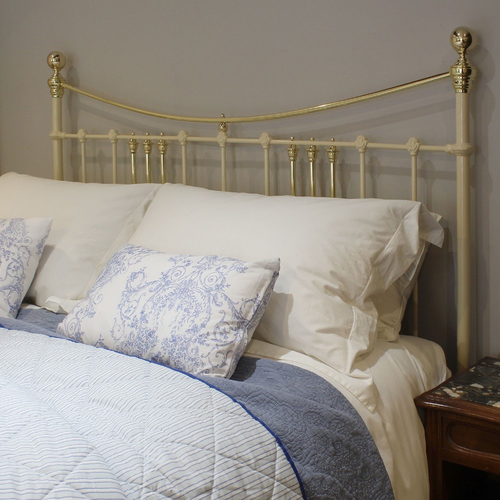 An antique king-size cream-painted metal bedstead featuring polished brass top rails, brass finials, and vertical spindle detailing. View VIII