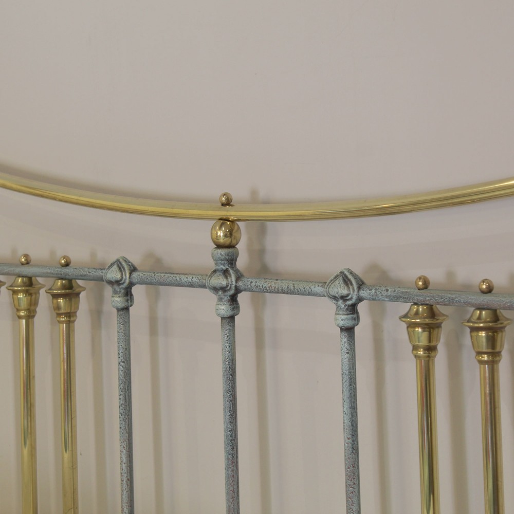 An antique king size bedstead featuring a light blue verdigris painted finish on iron spindles, accented by brass top rails and brass finials. View IX