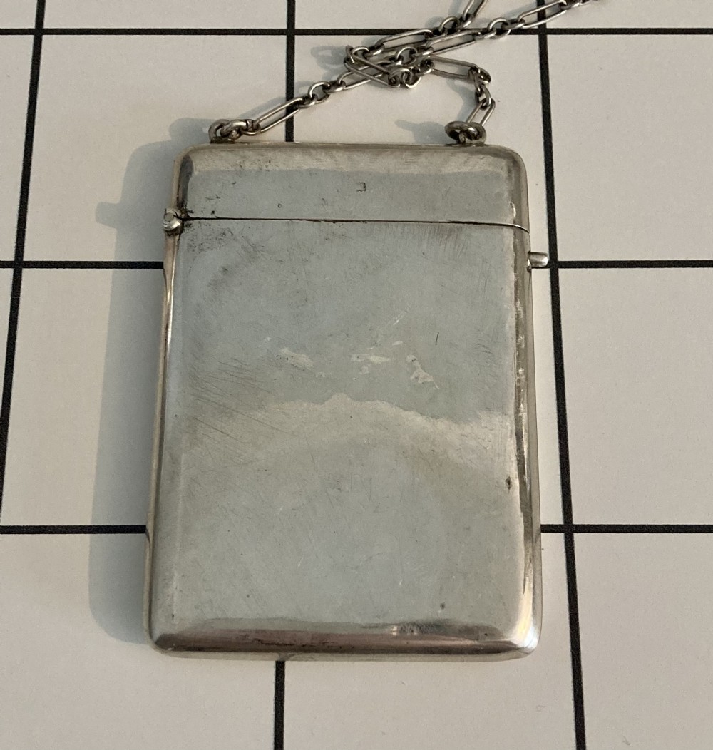 A rectangular sterling silver calling card case featuring a smooth polished surface, hinged top lid, and an attached link silver chain.