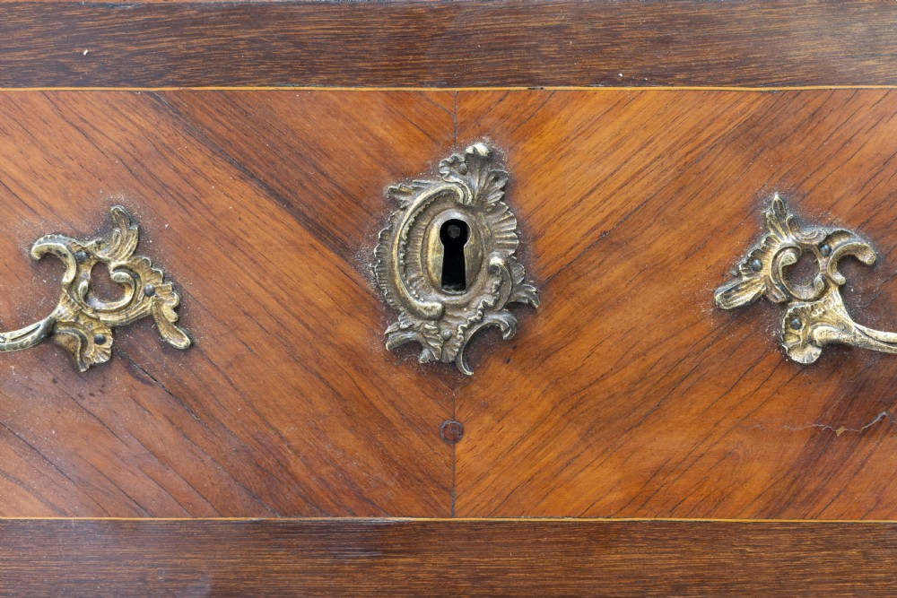 A tall, narrow French semainier chest of drawers featuring geometric wood parquetry, seven drawers, gilt bronze hardware, and a white marble top. View IV