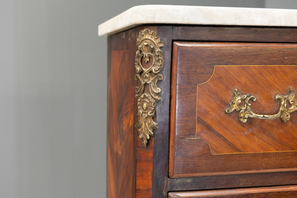 A tall, narrow French semainier chest of drawers featuring geometric wood parquetry, seven drawers, gilt bronze hardware, and a white marble top. View V