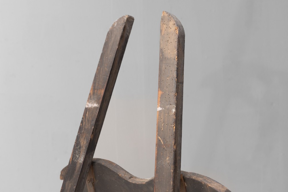 A tall, dark patinated pine A-frame studio easel featuring adjustable rest pegs and a carved decorative upper crossbar. View III