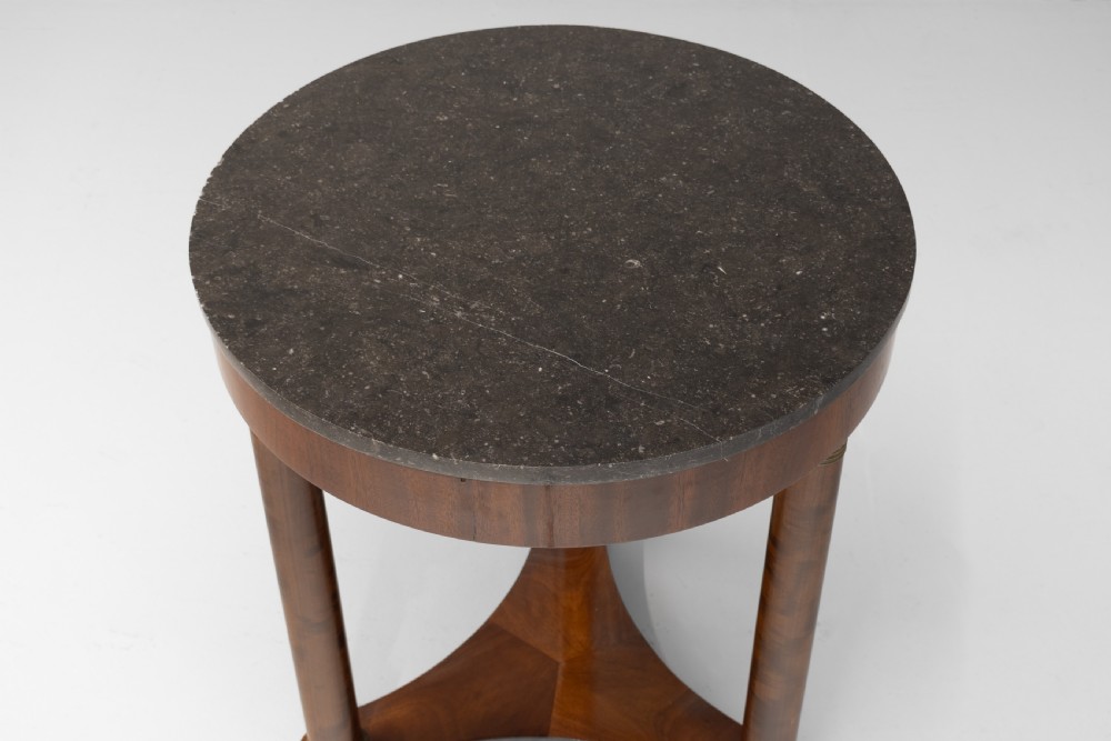 A French Empire style circular mahogany gueridon table featuring a dark marble top supported by three cylindrical columns on a tri-form base. View III