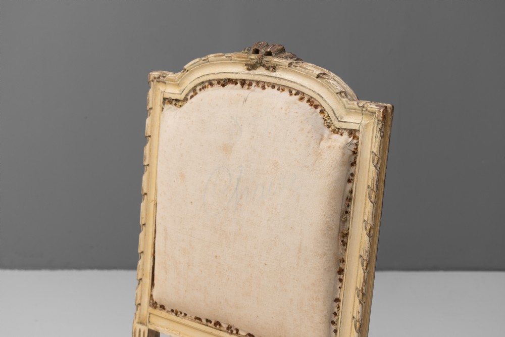 A pair of French Louis XVI style side chairs featuring distressed cream painted frames, tapered fluted legs, and neutral fabric upholstery. View IV