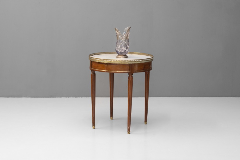 A circular Louis XVI style mahogany bouillotte table featuring a white marble top with a pierced brass gallery rim and fluted tapered legs. View II