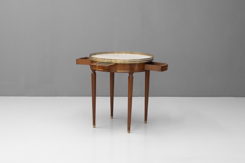 A circular Louis XVI style mahogany bouillotte table featuring a white marble top with a pierced brass gallery rim and fluted tapered legs. View III