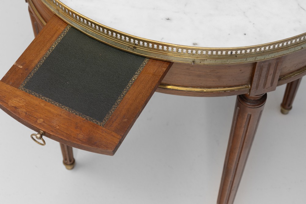 A circular Louis XVI style mahogany bouillotte table featuring a white marble top with a pierced brass gallery rim and fluted tapered legs. View VII