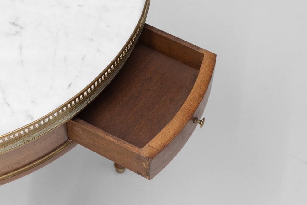 A circular Louis XVI style mahogany bouillotte table featuring a white marble top with a pierced brass gallery rim and fluted tapered legs. View VIII