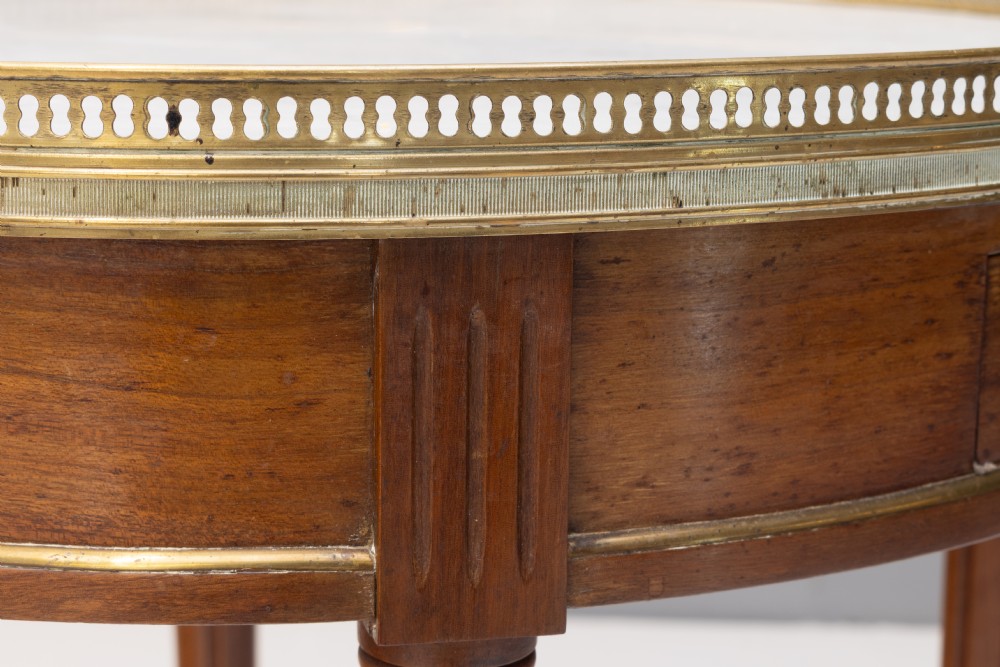A circular Louis XVI style mahogany bouillotte table featuring a white marble top with a pierced brass gallery rim and fluted tapered legs. View IX