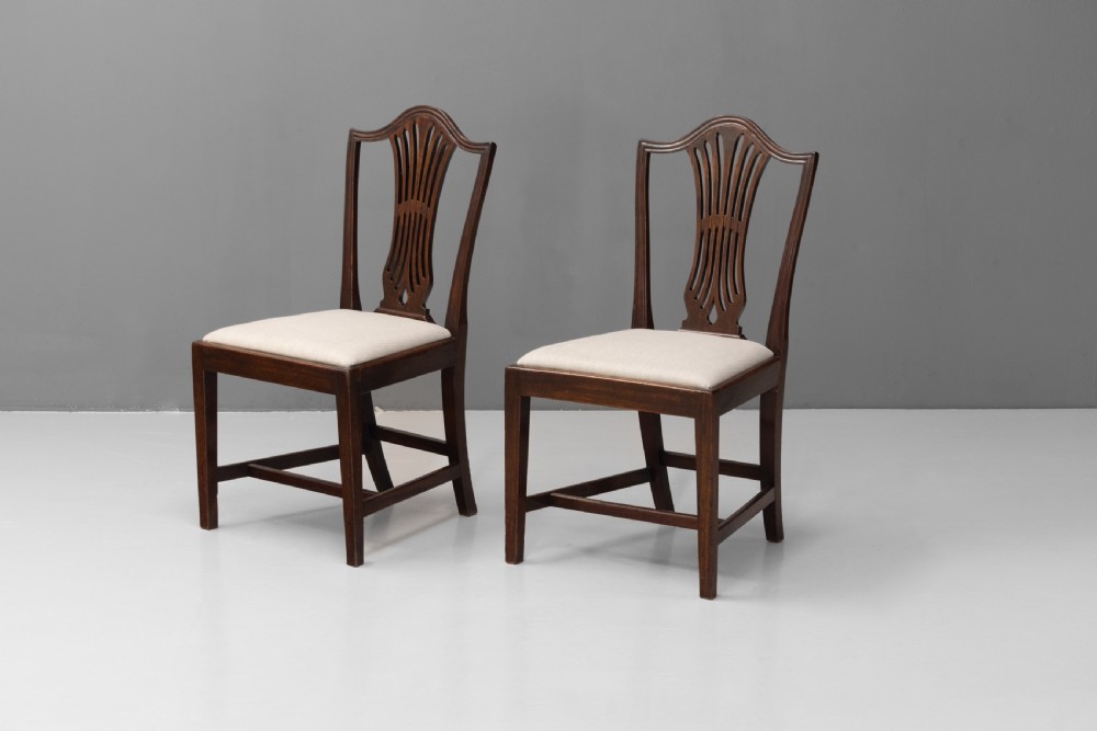 A set of six dark mahogany dining chairs featuring pierced splat backs, square stretchered legs, and light cream upholstered drop-in seats. View II