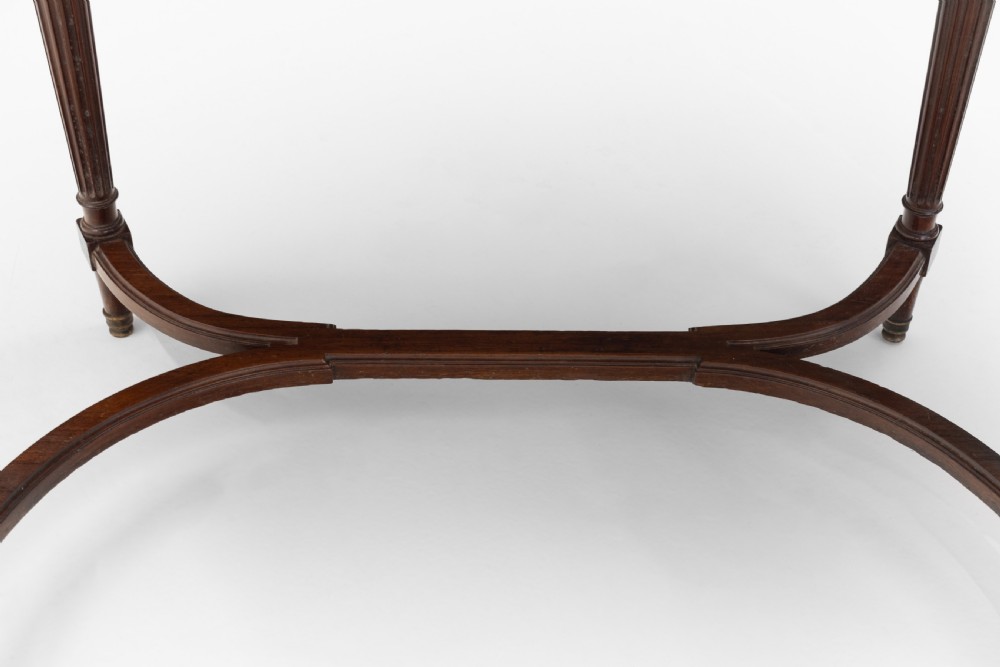 A mahogany kidney-shaped writing desk with a dark leather inset top, gilt-bronze mounts, four side drawers, and fluted legs joined by a curved stretcher. View VII