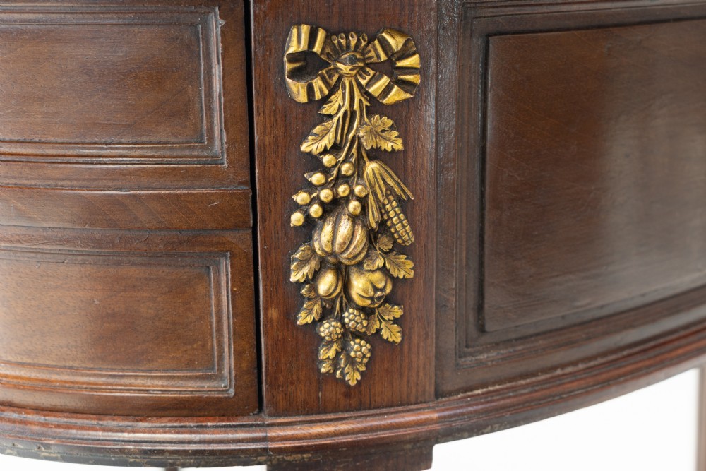 A mahogany kidney-shaped writing desk with a dark leather inset top, gilt-bronze mounts, four side drawers, and fluted legs joined by a curved stretcher. View VIII